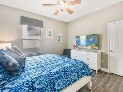 a bedroom with a blue bed and a ceiling fan at Ohana House at Windsor Hills, Disney World Luxury Rental in Orlando