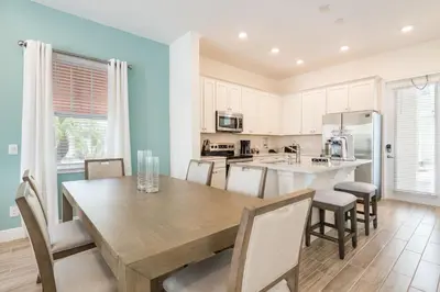 a kitchen and dining room with a wooden table and chairs at Vibrant Cottage Near Disney With Margaritaville Resort & Island H20 Waterpark Access- 3000Sp in Orlando