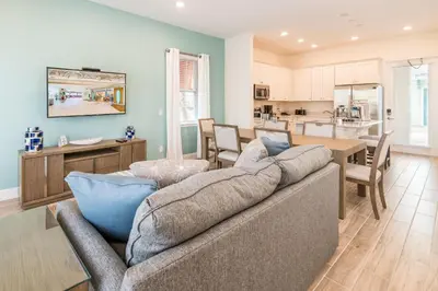 a living room with a couch and a kitchen at Vibrant Cottage Near Disney With Margaritaville Resort & Island H20 Waterpark Access- 3000Sp in Orlando