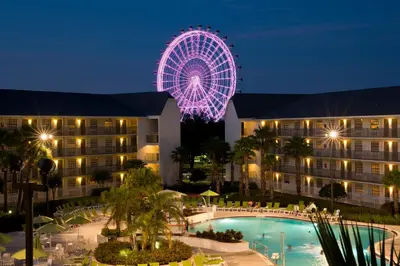 a ferris wheel at night in front of a hotel at Avanti International Resort in Orlando