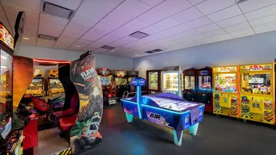 a room with arcade games and a room with consoles at Avanti International Resort in Orlando