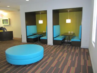 a waiting room with blue chairs and tables in a hospital at Avanti International Resort in Orlando