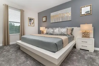 a bedroom with a large bed and a window at Villa wPrivate Pool &Themed Rooms, near Disney in Kissimmee