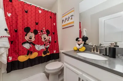 a bathroom with a mickey mouse shower curtain at Villa wPrivate Pool &Themed Rooms, near Disney in Kissimmee