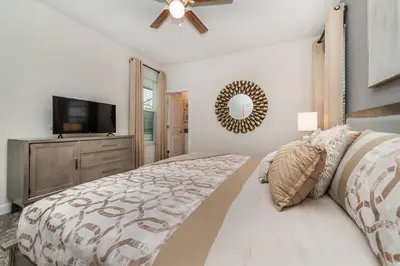 a bedroom with a bed and a flat screen tv at Villa wPrivate Pool &Themed Rooms, near Disney in Kissimmee
