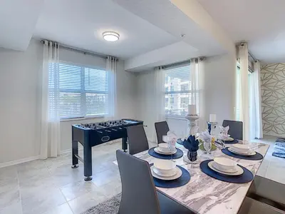 a dining room with a table and a piano at Updated Condo, 5 mi to Disney, On-site Water Park in Kissimmee