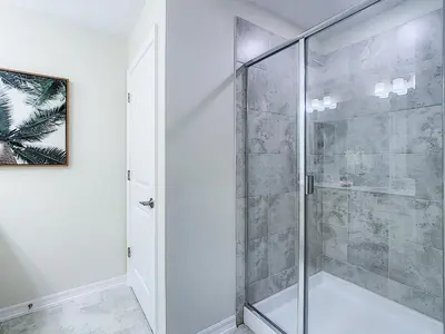 a shower with a glass door in a bathroom at Updated Condo, 5 mi to Disney, On-site Water Park in Kissimmee