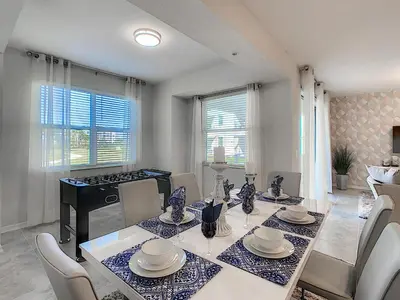 a dining room with a white table and chairs and a table and chairsktop at 3150 Paradox Circle 107 in Kissimmee