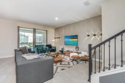 a living room with a gray couch and chairs at VILLA wPrivate Pool & Game Room near Disney in Kissimmee