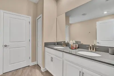 a bathroom with two sinks and a large mirror at VILLA wPrivate Pool & Game Room near Disney in Kissimmee