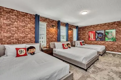 a bedroom with two beds and a brick wall at VILLA wPrivate Pool & Game Room near Disney in Kissimmee