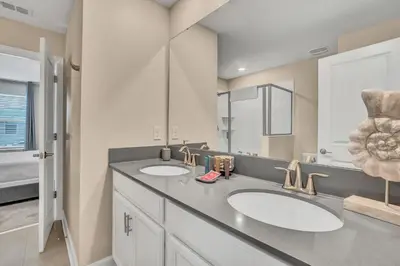 a bathroom with two sinks and a large mirror at VILLA wPrivate Pool & Game Room near Disney in Kissimmee