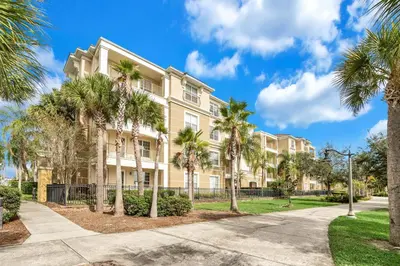 a large apartment building with palm trees in front of it at 4816 Cayview Ave #306 in Orlando
