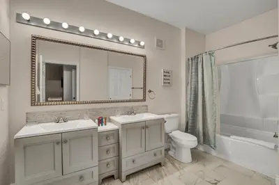 a bathroom with two sinks and a mirror and a toilet at 7664 Comrow Street #104 in Orlando