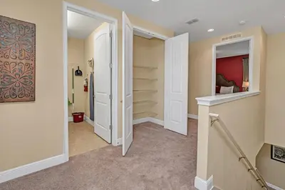 a hallway with a walk in closet with white doors at Modern Villa wPrivate Pool and Air Hockey Table in Orlando