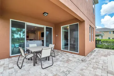 a patio with a table and chairs on a patio at Modern Villa wPrivate Pool and Air Hockey Table in Orlando