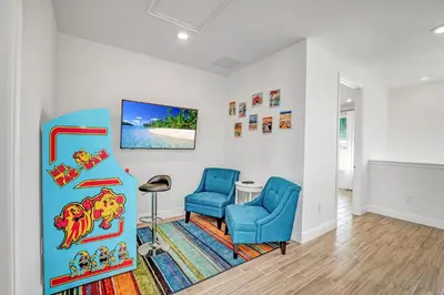 a living room with a blue chair and a table at Large Margaritaville Villa w PRIVATE POOL View in Orlando