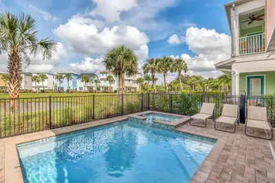 a swimming pool with two chairs and a fence at Large Margaritaville Villa w PRIVATE POOL View in Orlando