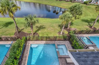 an overhead view of two swimming pools with palm trees at Large Margaritaville Villa w PRIVATE POOL View in Orlando