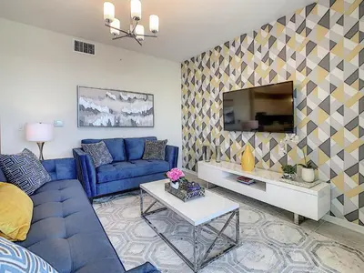 a living room with a blue couch and a tv at 3131 Paradox Cir Unit 203 in Kissimmee