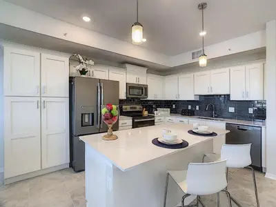 a kitchen with white cabinets and a kitchen island with chairs at 3131 Paradox Cir Unit 203 in Kissimmee