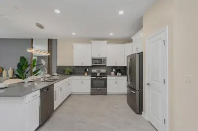 a kitchen with white cabinets and stainless steel appliances at 4520 Target Blvd in Kissimmee