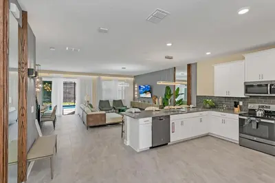 a kitchen with white cabinets and a living room at 4520 Target Blvd in Kissimmee