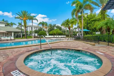 a large pool with a hot tub in a yard with palm trees at Vista Cay at Epic Universe - Standard 3 bedroom penthouse in Orlando