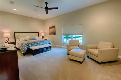 a bedroom with a bed and a couch and a chair at Mickeys Atlantis - Luxury 8BR Mansion Oasis Pool Hot Tub Outdoor Kitchen Home Theater, Game Room & More! 2 Miles to Disney in Orlando