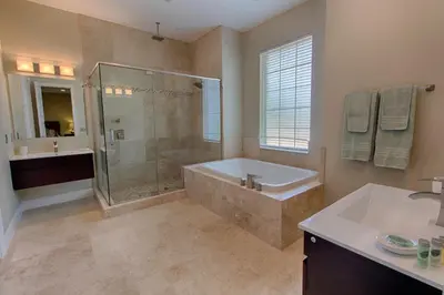 a bathroom with a tub and a shower and a sink at Mickeys Atlantis - Luxury 8BR Mansion Oasis Pool Hot Tub Outdoor Kitchen Home Theater, Game Room & More! 2 Miles to Disney in Orlando