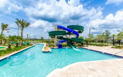 a water slide in a pool at a resort at Beautiful apartment in lux Storey Lake community 10 miles to Disney! in Kissimmee