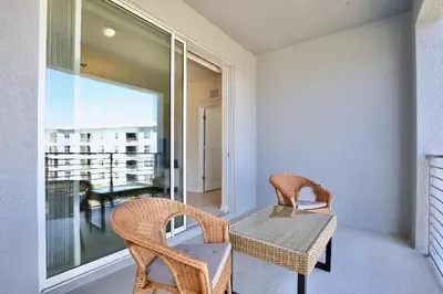 a room with a table and chairs and a balcony at Beautiful apartment in lux Storey Lake community 10 miles to Disney! in Kissimmee