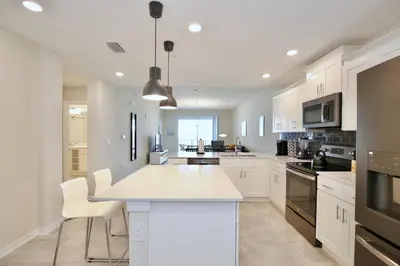 a kitchen with white cabinets and a white counter top at Beautiful apartment in lux Storey Lake community 10 miles to Disney! in Kissimmee