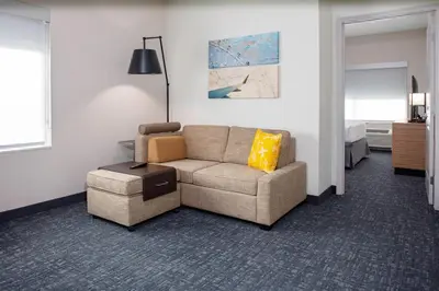 a living room with a couch and a bed at TownePlace Suites by Marriott Orlando Airport in Orlando