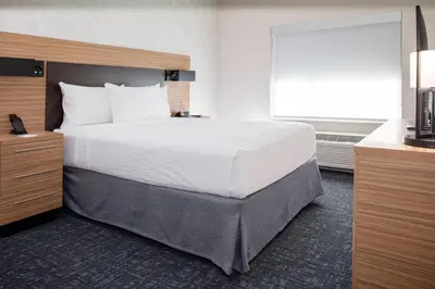 a hotel room with a large bed and a window at TownePlace Suites by Marriott Orlando Airport in Orlando