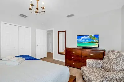 a bedroom with a bed and a couch and a television at Roomy Town Home, Mickey-Themed Bedroom! #4BV550 in Kissimmee