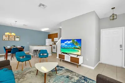 a living room with a couch and a tv on a wall at Roomy Town Home, Mickey-Themed Bedroom! #4BV550 in Kissimmee