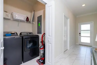 a kitchen with a washer and dryer in a room at Stunning 5 Bd w/ Pool Close to Disney 2905 in Kissimmee