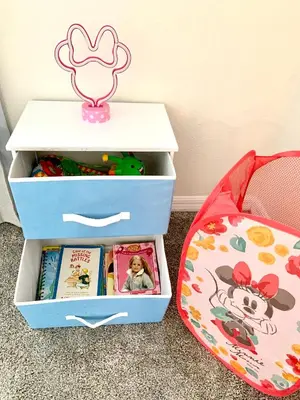 a drawers filled with books next to a suitcase at 3B2B-Beautiful Lake View-Baby Friendly-FREE WATER PARK!NO Resort Fee-5 Miles to Disney-Storey Lake 3141 in Kissimmee