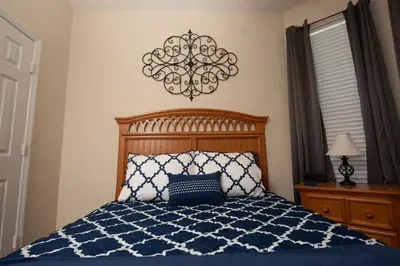 a bedroom with a bed with a blue and white comforter at Magical Adventure Condo w Waterpark near Disney No Resort Fees in Orlando