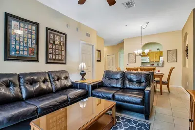 a living room with a leather couch and a table at Magical Adventure Condo w Waterpark near Disney No Resort Fees in Orlando
