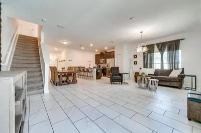an open living room with a staircase and a living room at 7 Mi Walt Disney World! Family Gem with Private Pool in Kissimmee