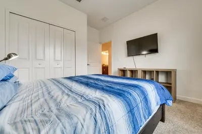 a bedroom with a bed and a flat screen tv at 7 Mi Walt Disney World! Family Gem with Private Pool in Kissimmee