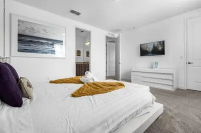 a white bedroom with two beds and a dresser at 371P Fabulous 8 BD Private PoolSpa- By Disney in Orlando