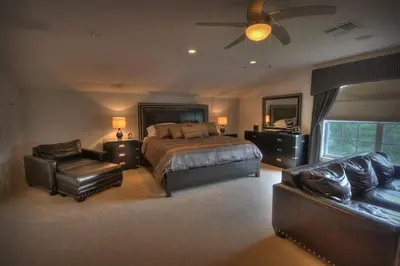 a large bedroom with a bed and a couch at Mickeys Getaway - CUSTOM 8BR Luxurious Retreat Pool Hot Tub Theater RM Gym! Outdoor Kitchen 2 Miles to Disney in Orlando