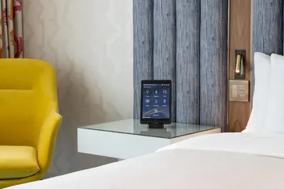 a cell phone sitting on a glass table next to a bed at Lake Nona Wave Hotel in Orlando
