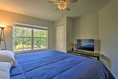 a bedroom with a large blue bed and a tv at 10 Mi to Disney Venetian Bay Villages Retreat in Kissimmee