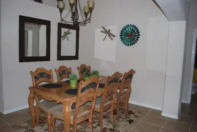 a dining room with a wooden table and chairs at Luxury 5-Bed Villa, located only 3 miles from Disney World in Kissimmee