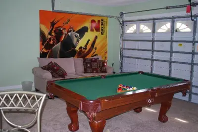 a living room with a pool table and a couch at Luxury 5-Bed Villa, located only 3 miles from Disney World in Kissimmee