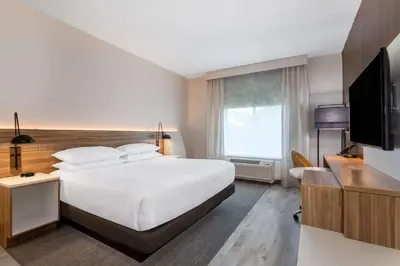 a hotel room with a large bed and a television at Wyndham Garden Orlando Airport - Free Airport Shuttle in Orlando